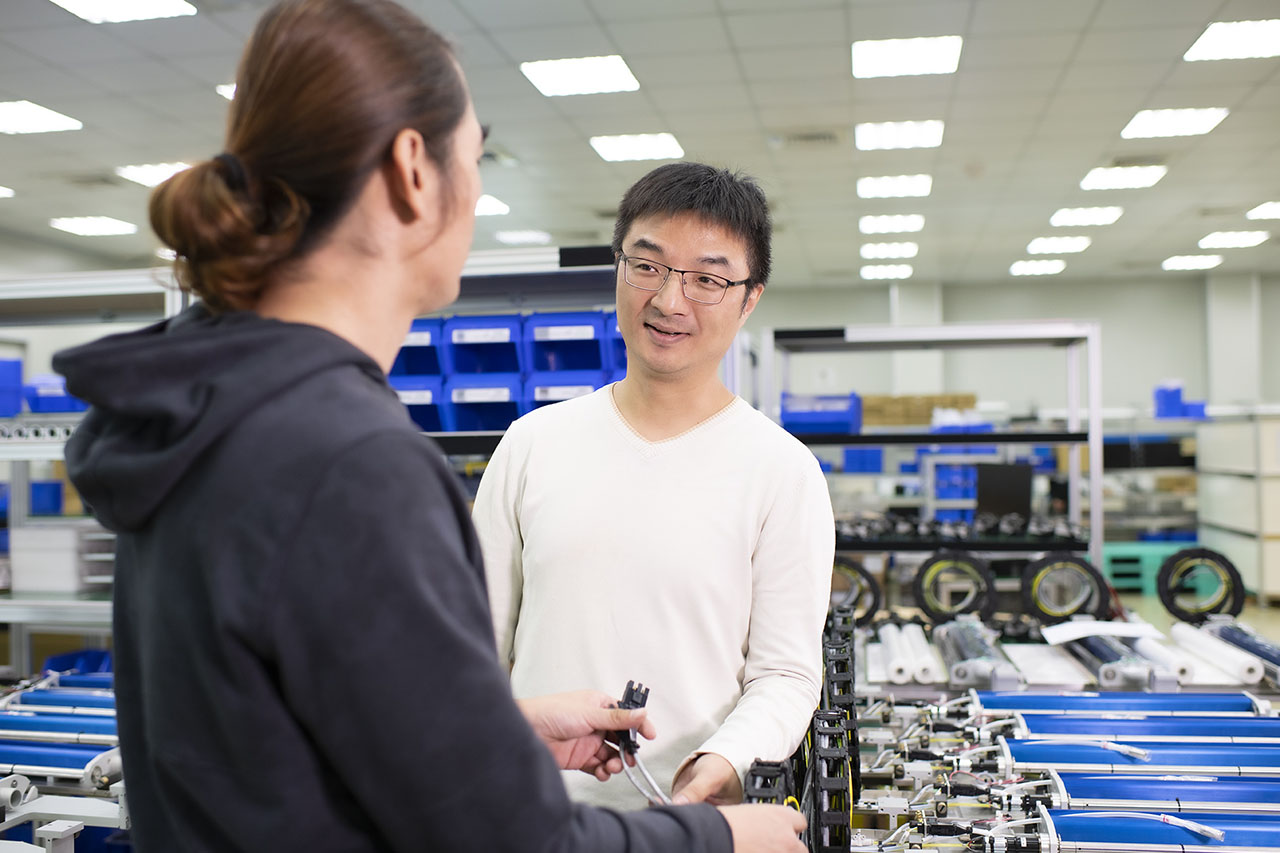 SHL Technologies Senior Engineer Weber Yu and a colleague discussing a project for a PCB printing machine module.